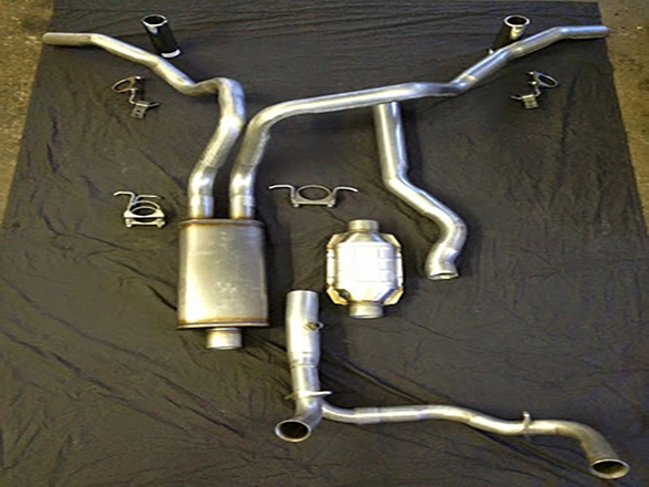 Complete custom dual exhaust pipe layout with muffler and catalytic converter on shop floor